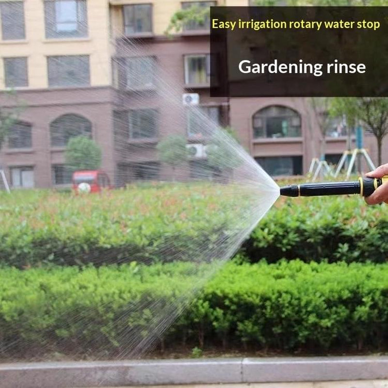 Adjustable garden hose nozzle spraying water on outdoor plants