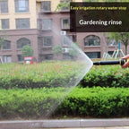 Adjustable garden hose nozzle spraying water on outdoor plants