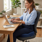 Woman working on a laptop while sitting on a navy blue seat cushion in a modern home office